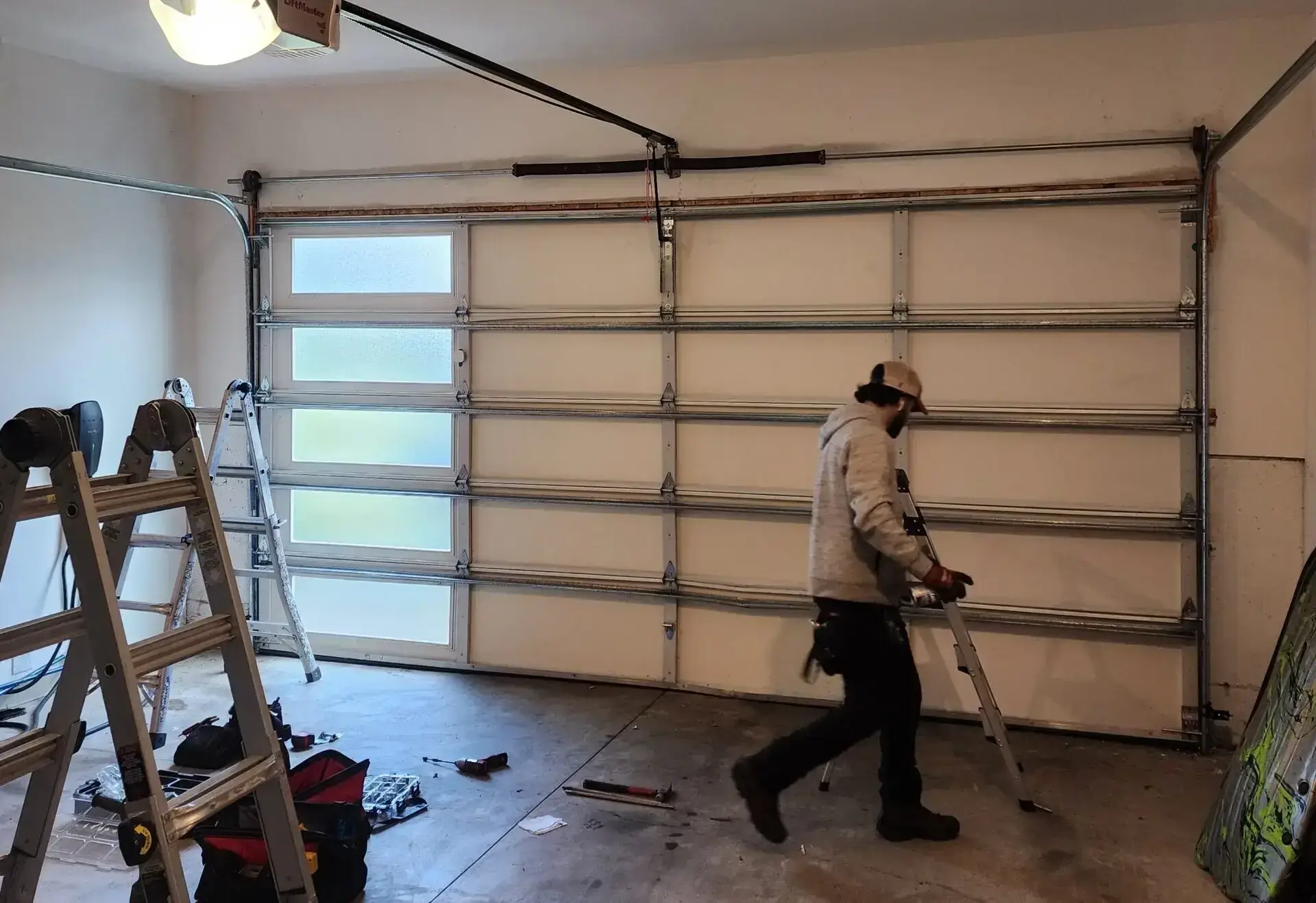 Man walking beside a ladder in a garage