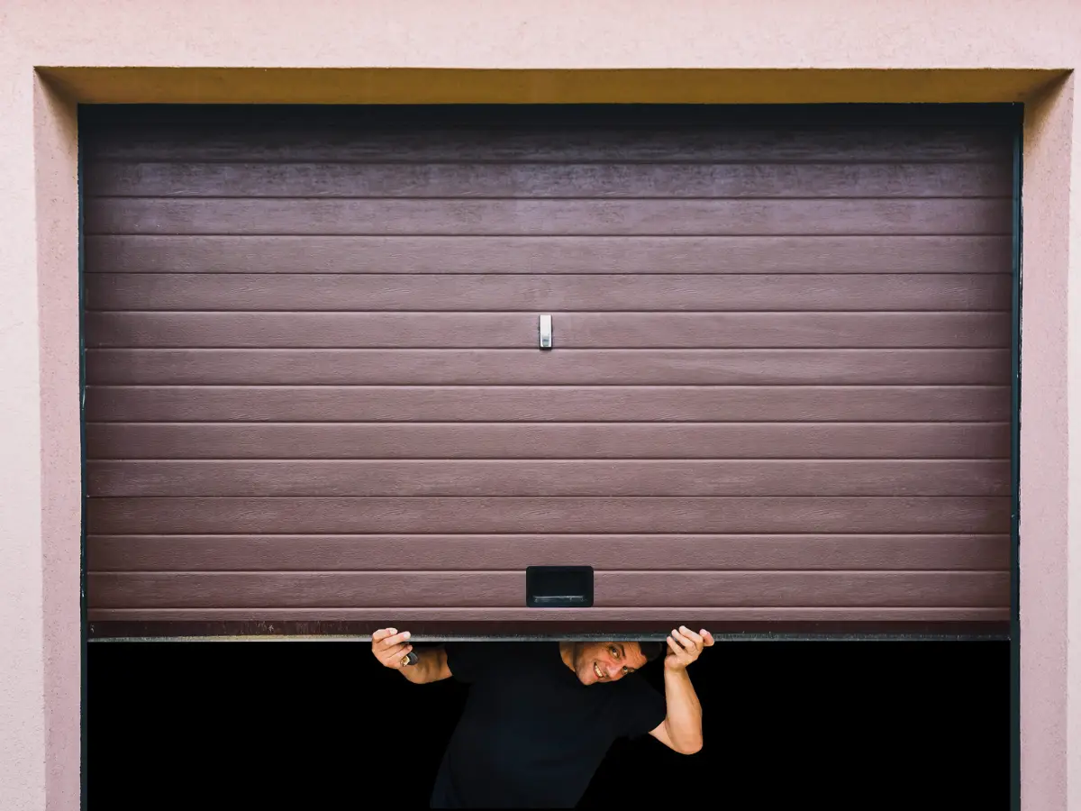Man lifting a partially open garage door
