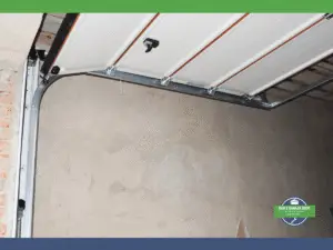 Section of a garage door mechanism showing tracks and tension spring.