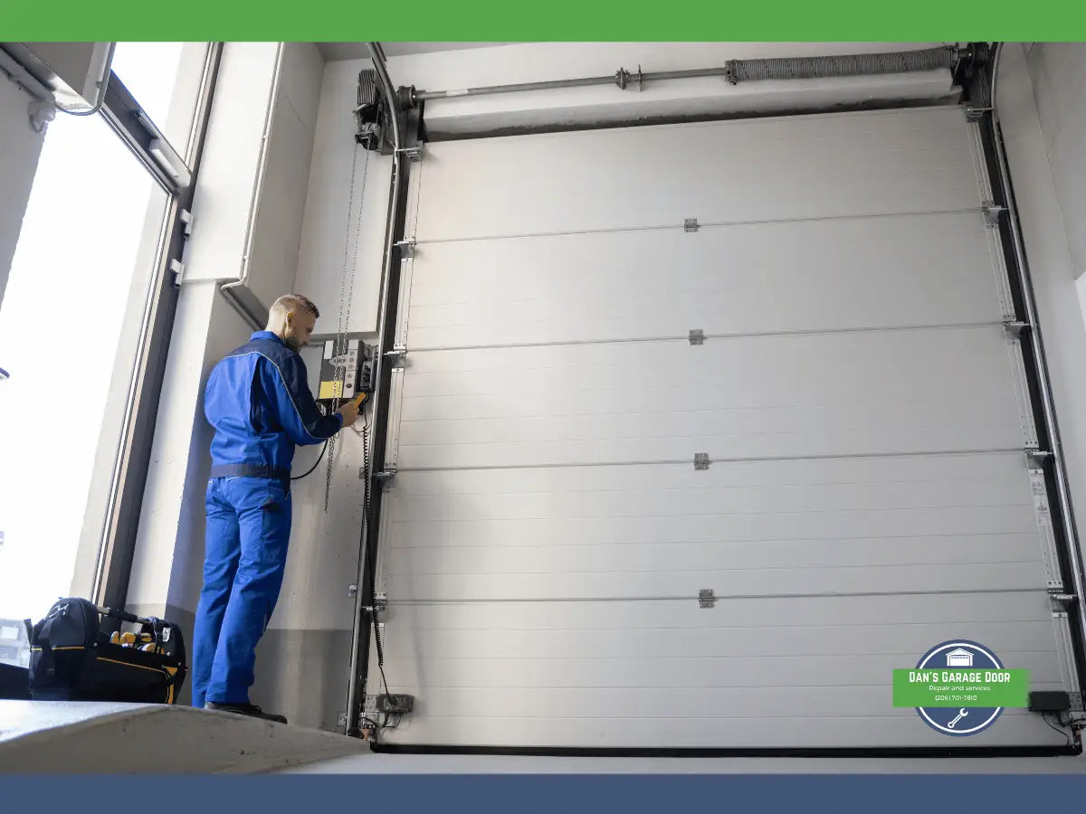 Technician in blue uniform checks garage door control panel