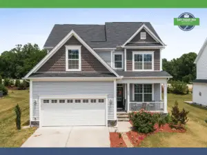 Two-story house with gray siding, brown accents, and a white garage door.