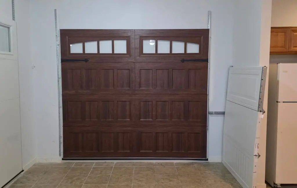 Brown paneled garage door with four small windows in a showroom