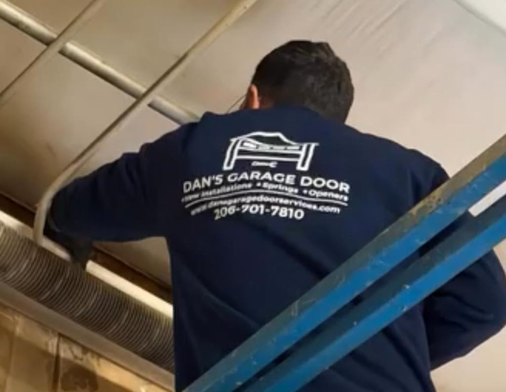 Technician on blue lift working on ceiling garage door opener