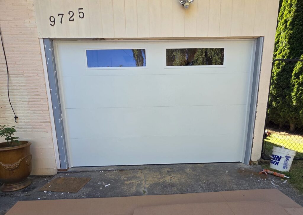 White garage door with two narrow windows and house number 9725