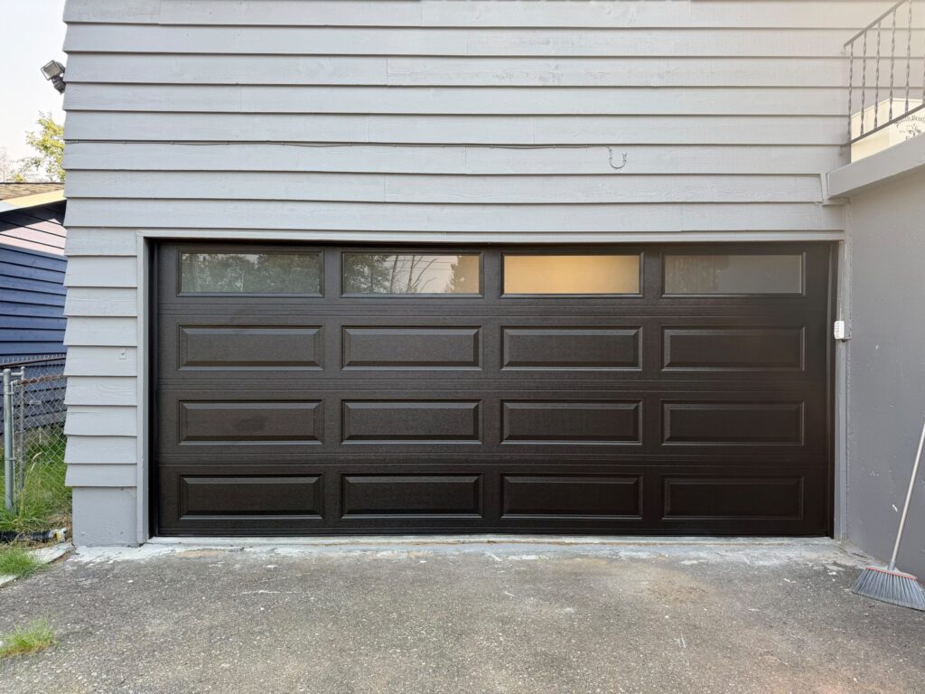 Black paneled garage door with four top windows