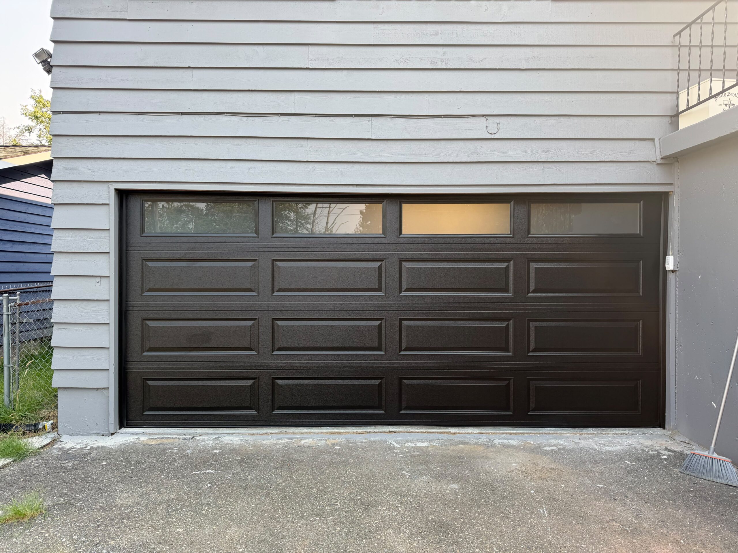 Black paneled garage door with four top windows