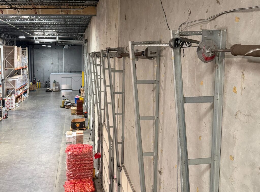 Industrial garage door mechanisms mounted along a warehouse wall