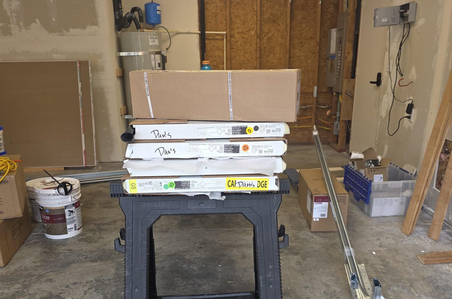 Boxes of building materials stacked on a sawhorse indoors