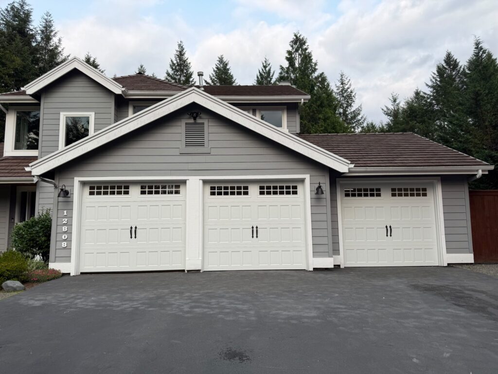 Gray house exterior with three white garage doors