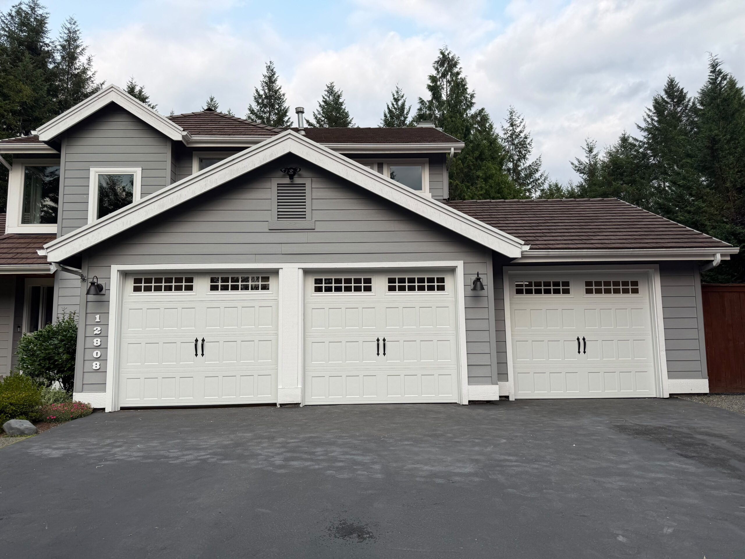 Gray house exterior with three white garage doors