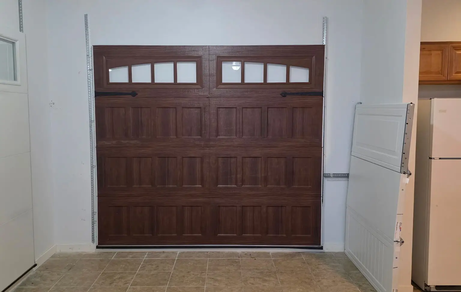 Brown paneled garage door with four small windows in a showroom