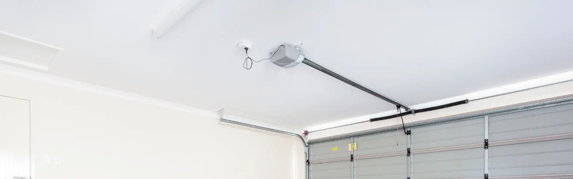 Ceiling-mounted garage door opener with black rail and opener unit