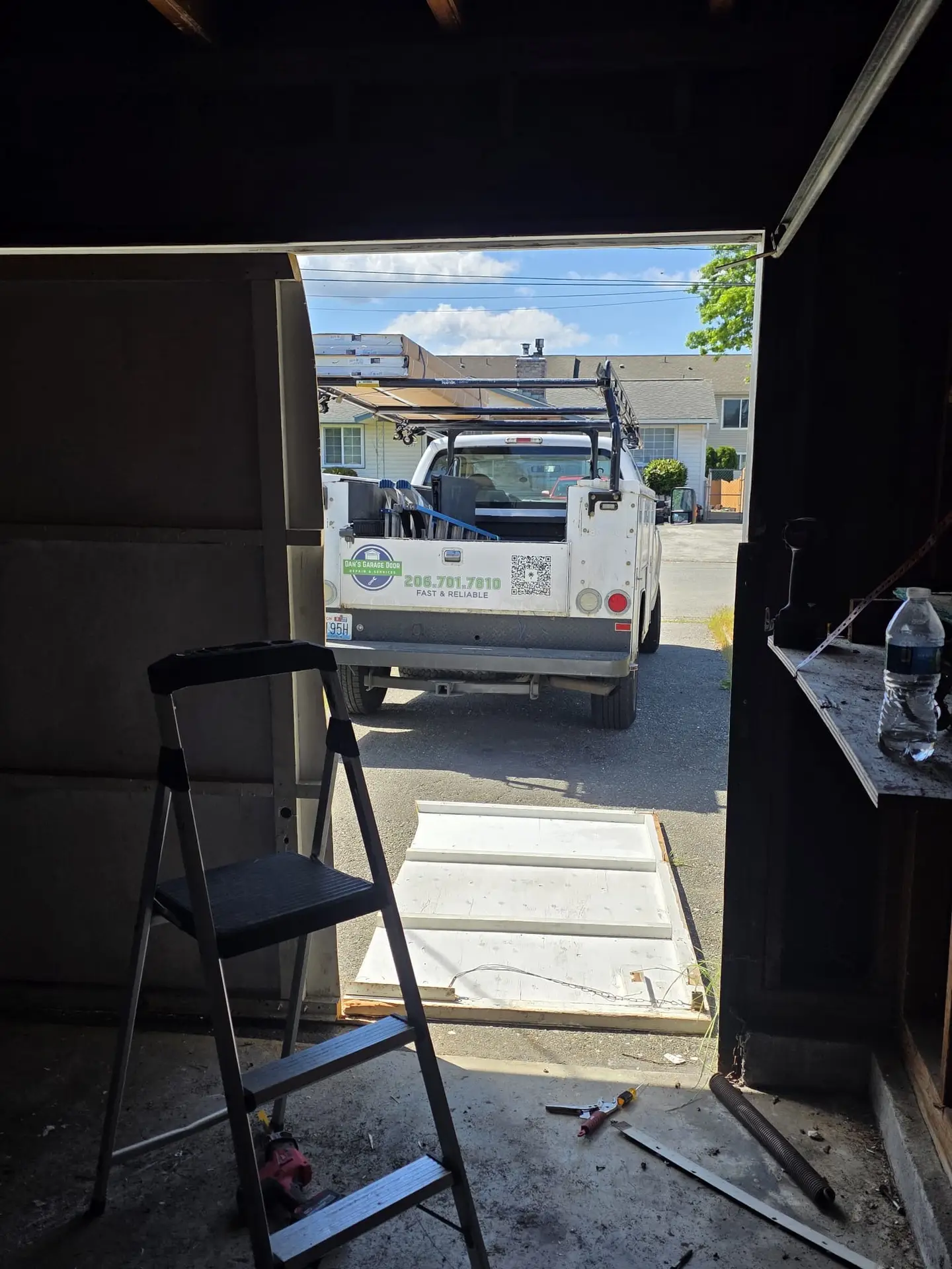 White work truck outside broken garage door opening