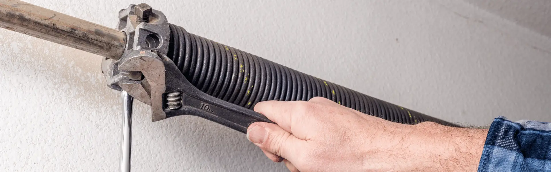 Hand tightening garage door torsion spring with wrench