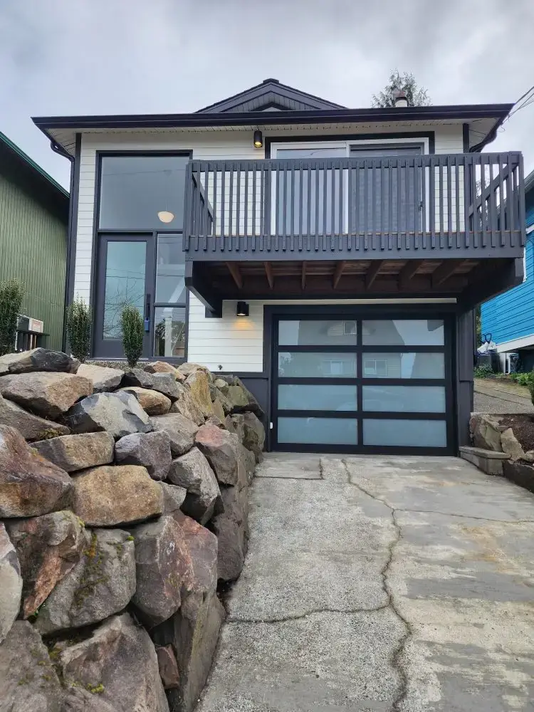 Modern two-story house with balcony and frosted garage door