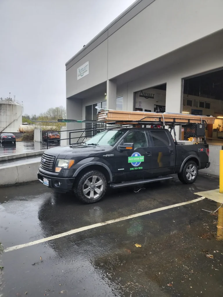 Black pickup truck carrying long boards outside Amarr building