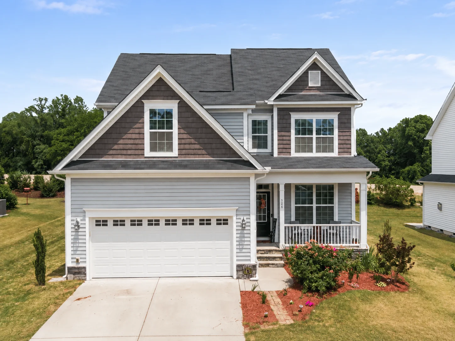 Two-story gray house with white attached garage door