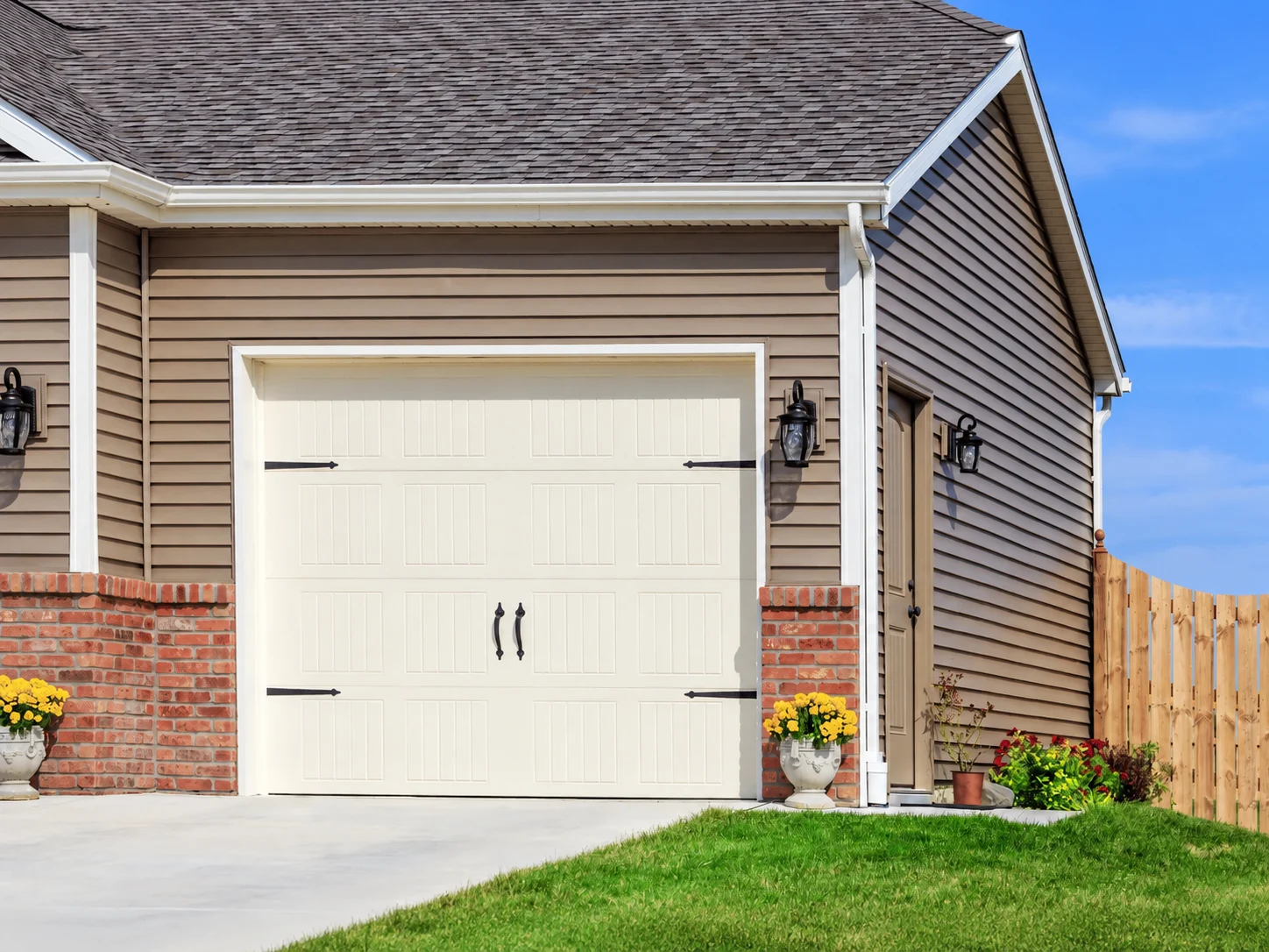 House exterior with beige garage door and side pedestrian door