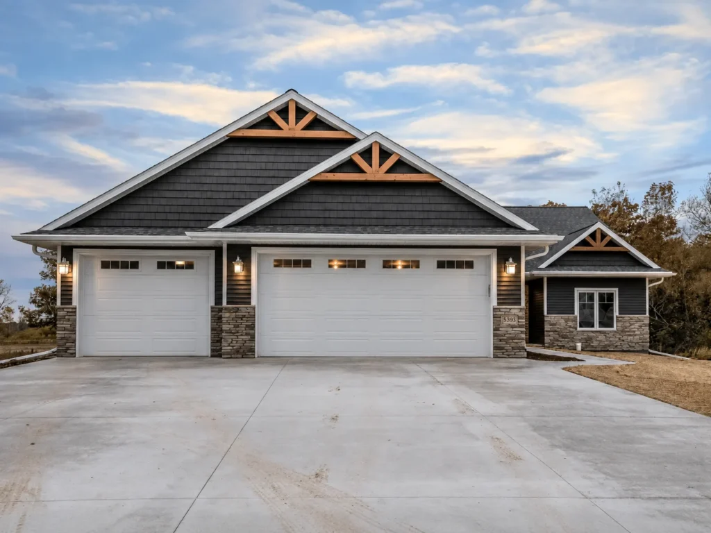 Modern house with two white garage doors and driveway