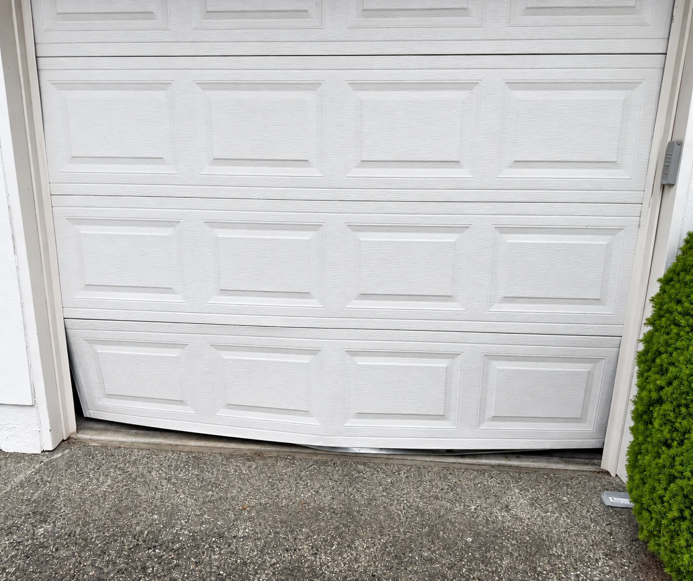 White garage door with Dan’s Garage Door Repair & Services logo