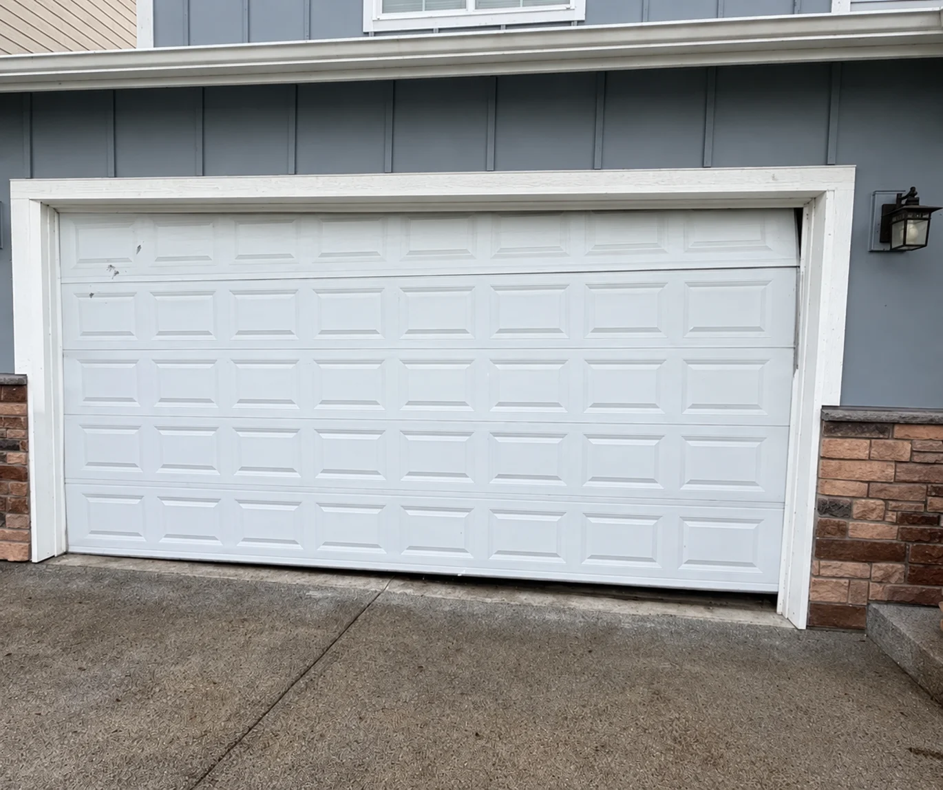 White garage door with DAN'S GARAGE DOOR REPAIR & SERVICES logo