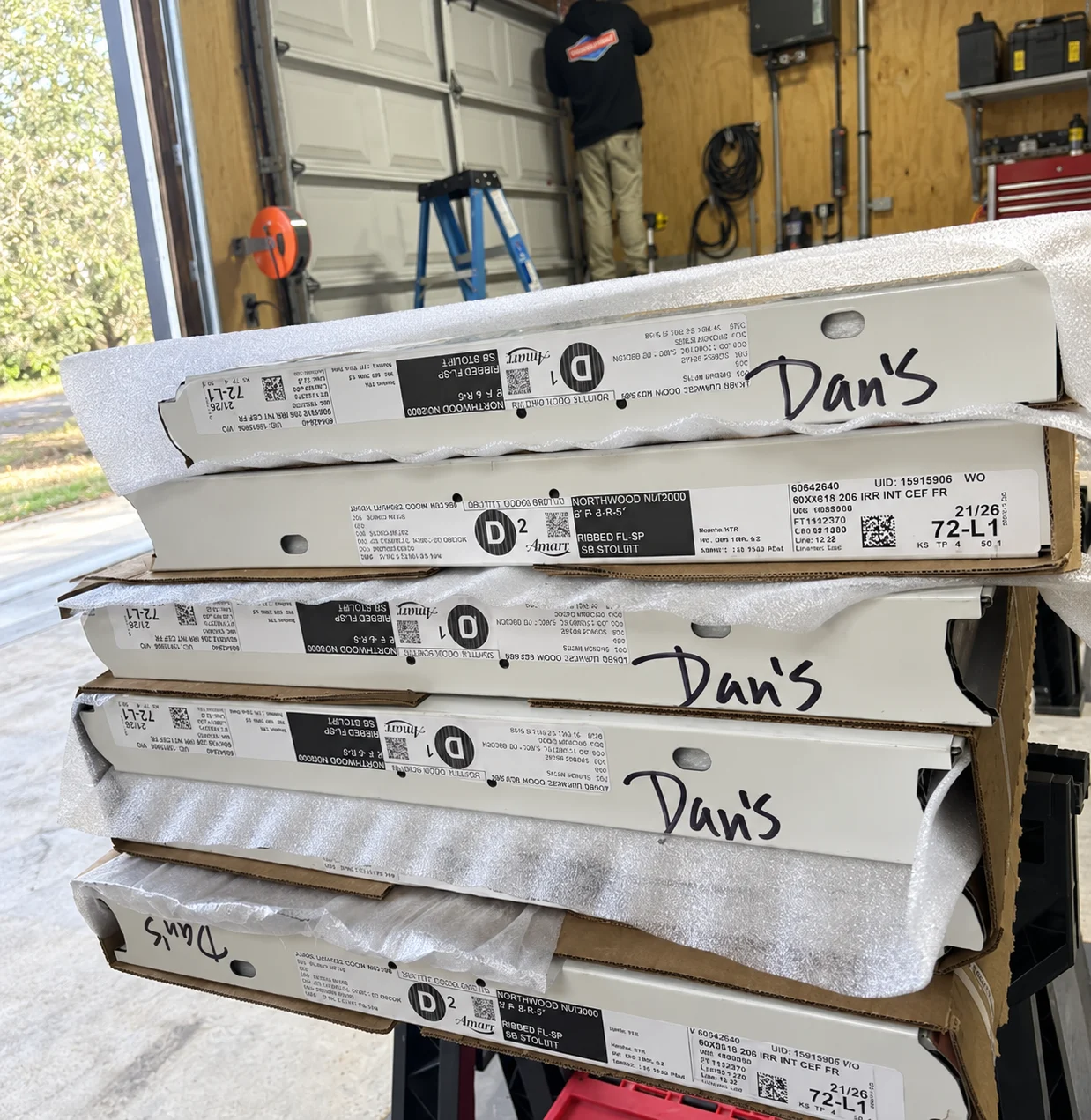 Stacked garage door panels with Dan’s Garage Door logo overlay