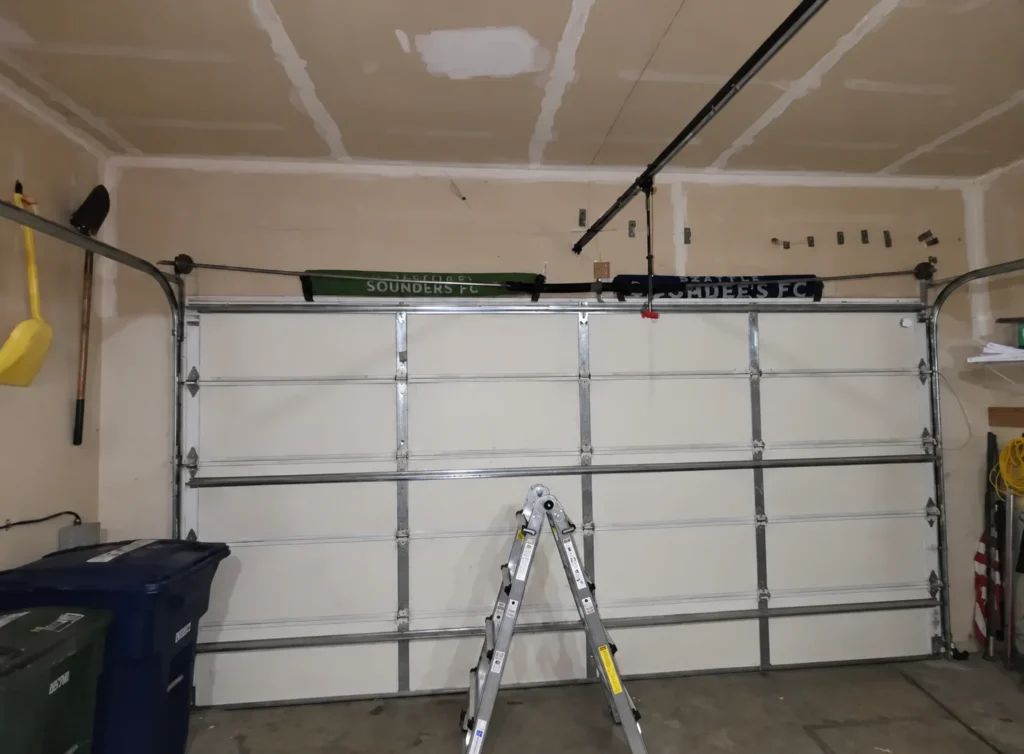 White garage door with ladder and highlighted upper bracket