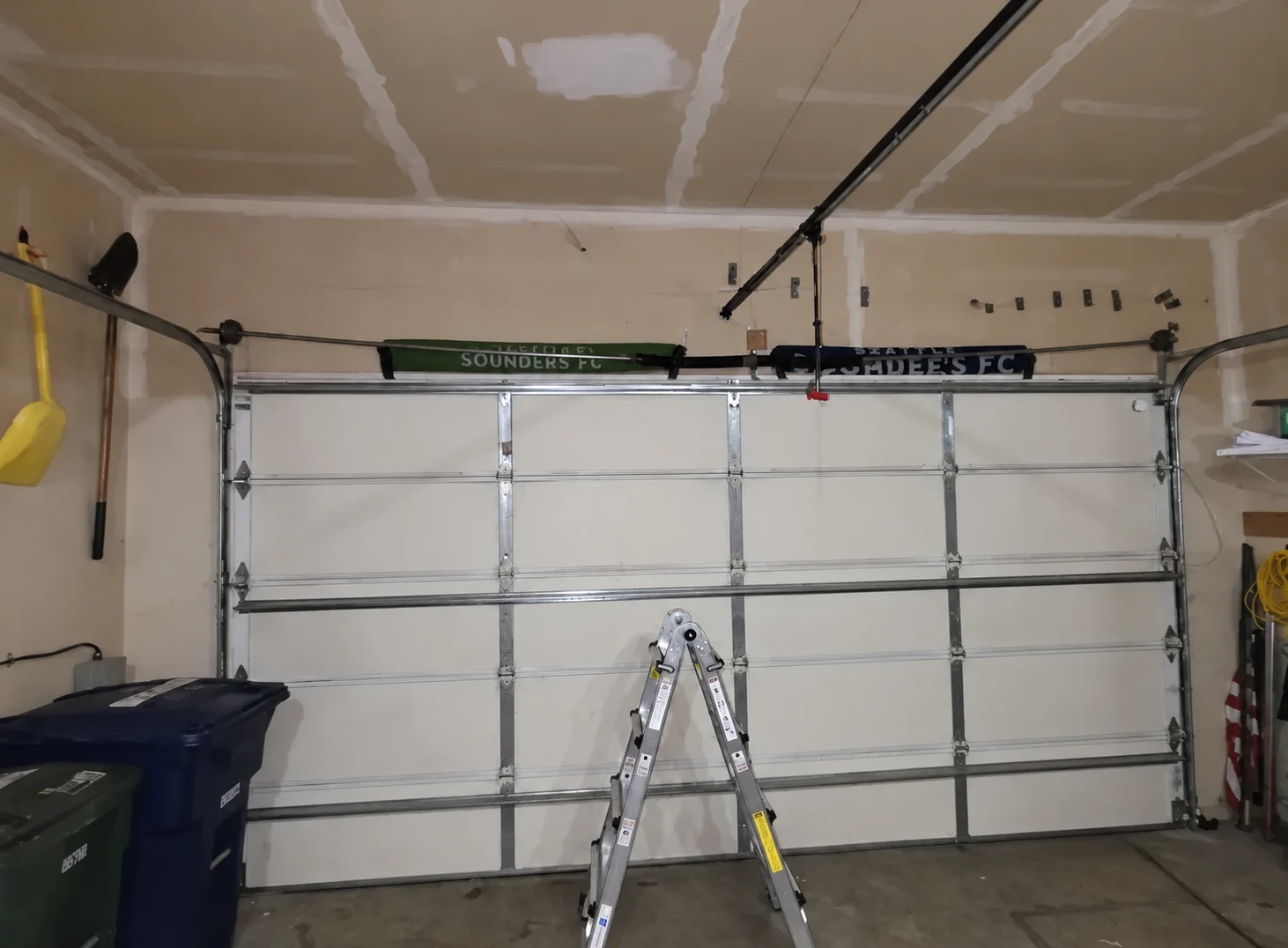 White garage door with ladder and highlighted upper bracket