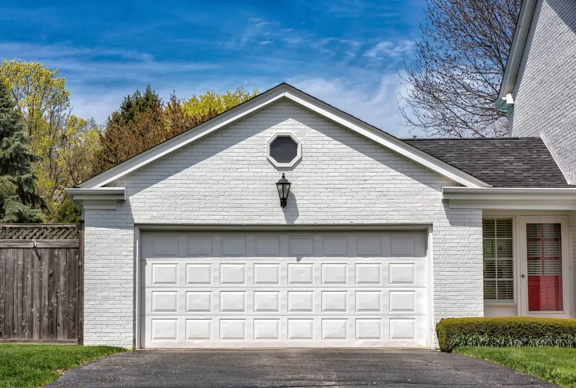 White brick garage with double white door and octagonal window